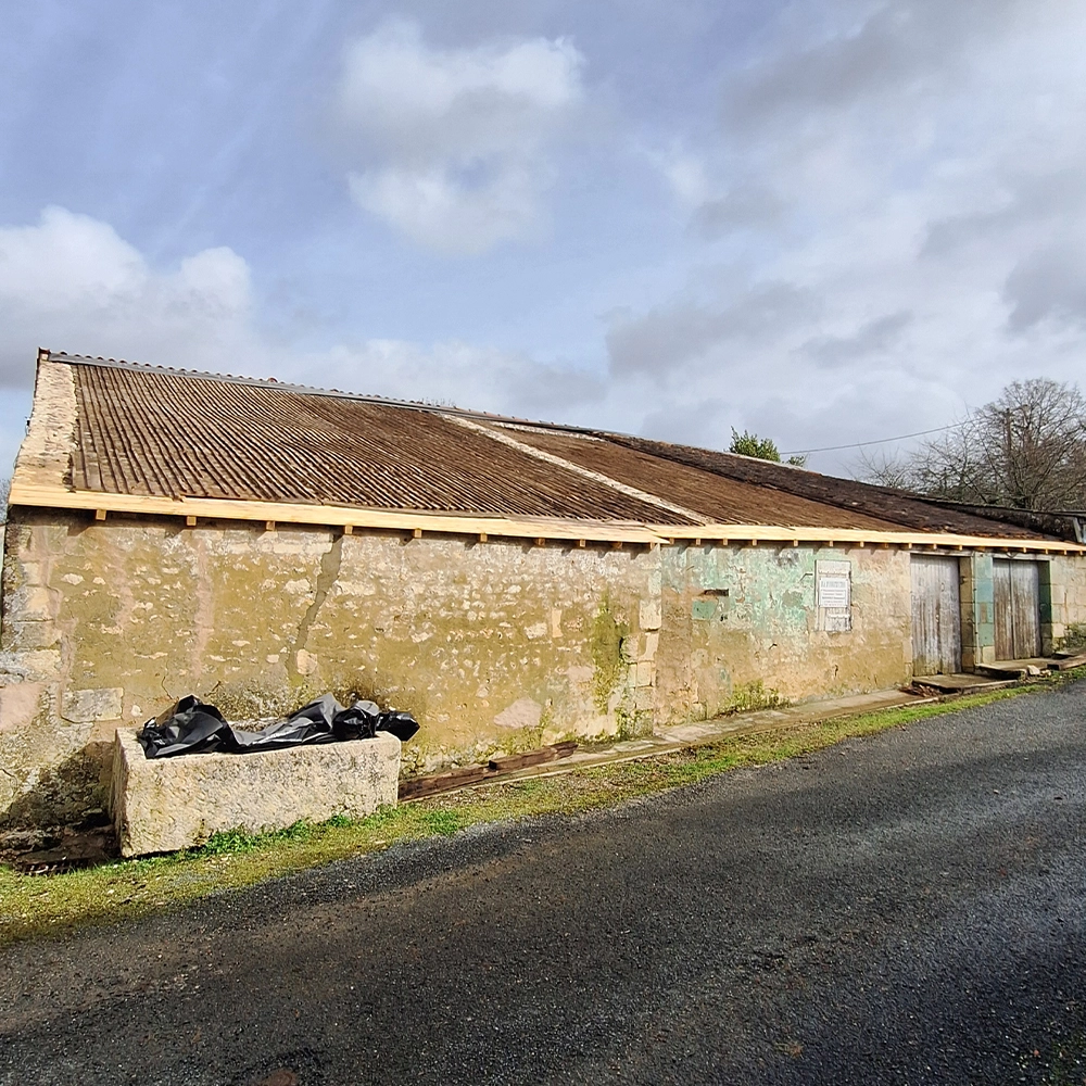 Dépôt en pierre avec toiture en fibrociment dégradée avant rénovation – chantier MM Construction en Charente-Maritime